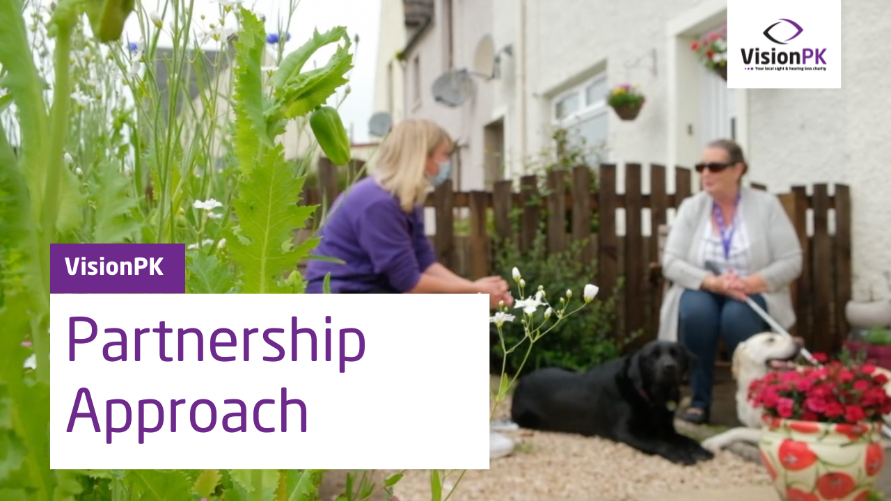 Screenshot from video of 2 people talking in a garden and a black guide dog. Title says partnership approach